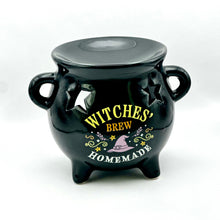 Load image into Gallery viewer, A glossy black ceramic cauldron-shaped container with a lid, featuring a 'Witches Brew Homemade' graphic with yellow and white lettering and a small purple hat illustration on the front.