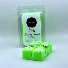 Load image into Gallery viewer, A bright neon green wax melt bar with black speckles in front of its clear plastic packaging, which features a white and neon green label reading 'Artistry' and 'Spooky Season'.
