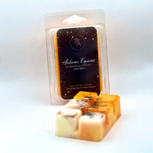 Load image into Gallery viewer, A packaged wax melt and several unwrapped wax melt cubes in front, photographed on a white studio background. The front cubes are pale cream with dark brown speckled swirls, and the packaged melt behind shows a dark label reading 'Autumn Equinox'.
