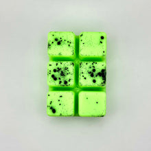 Load image into Gallery viewer, A small rectangular block of bright neon green wax melts with black speckles, arranged in a 2x3 grid on a white sheet.
