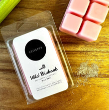 Load image into Gallery viewer, Artistry Wild Rhubarb wax melts in a clear plastic clamshell package, displayed on a wooden surface next to pink wax melts and a green stalk of rhubarb.
